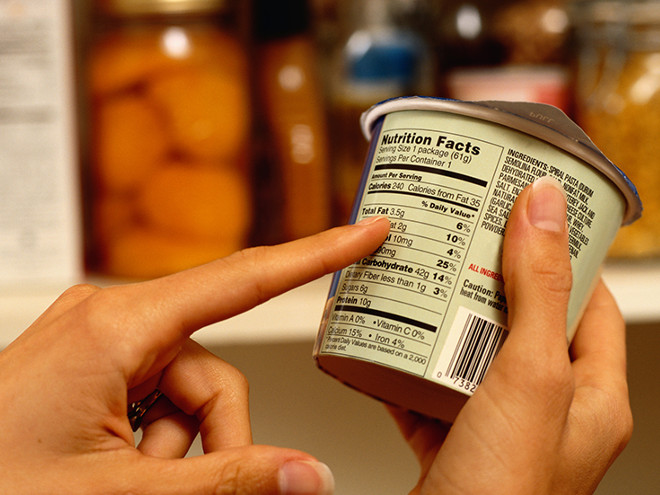 Person Reading Nutrition Label on Packaged Food